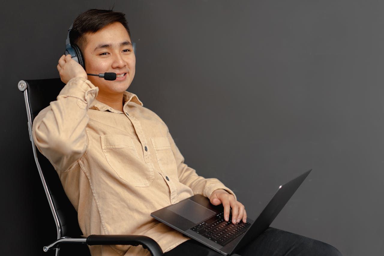 Apo VA client in a brown button-up shirt working on a laptop
